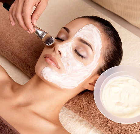 This is an alt text of a woman getting a facial applied with a brush.